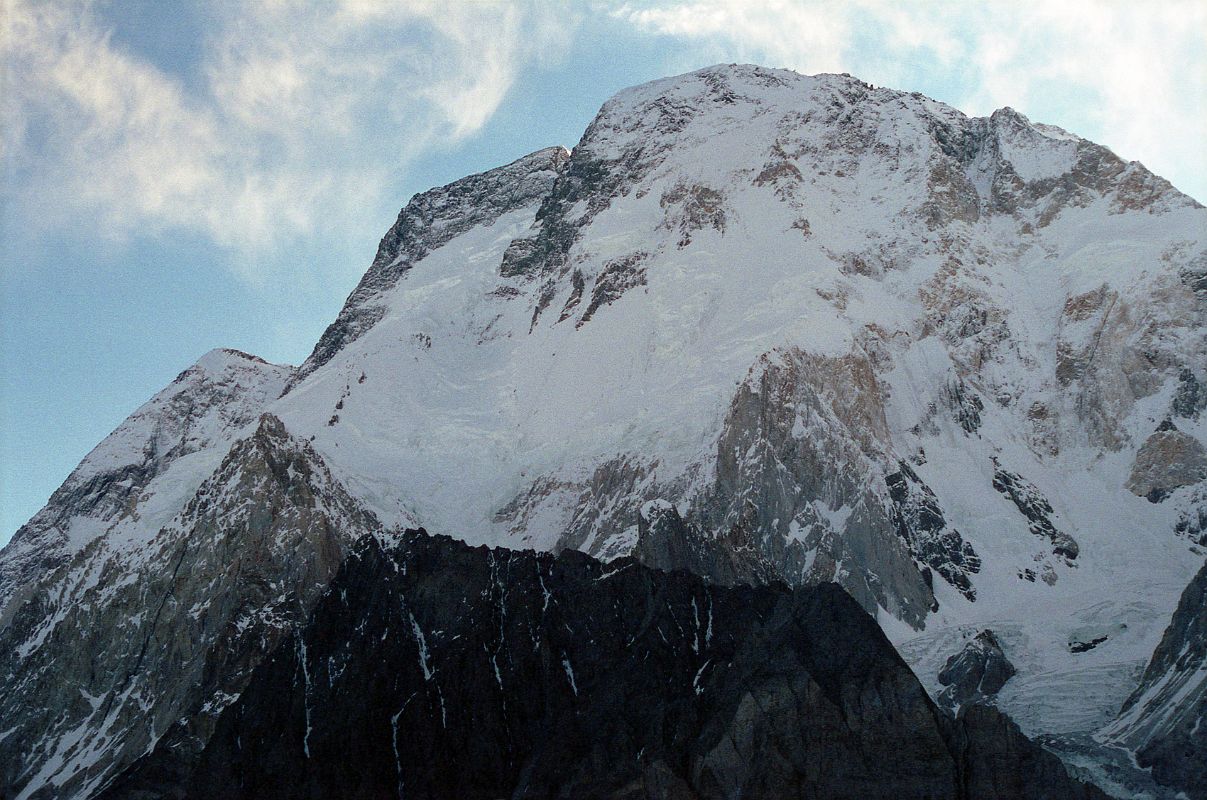 30 Broad Peak North Summit, Central Summit And Main Summit Just After Sunrise From Concordia The three summits of Broad Peak are seen at sunrise from Concordia. The North Summit is on the far left, the Central Summit is in the middle with just a touch of sun, and on the far right is the Main Summit. The first ascent of Broad Peak was completed by Marcus Schmuck, Fritz Wintersteller, Kurt Diemberger, and Hermann Buhl on June 9, 1957. This extremely small expedition marked a major step forward in the development of Himalayan climbing. Diemberger: �[Buhl's] plan was that from base camp onwards there would only be climbers on the mountain; they would do everything, load-carrying, establishment of camps and, finally, the assault on the summit. And it was all to be done without the use of oxygen.� Diemberger reached the summit just as Marcus Schmuck and Fritz Wintersteller started their descent. As Diemberger was descending from the summit he met Buhl still ascending. �Slowly, with all that incredible strength of his will, he started to move, very slowly, upwards. ... Two men were standing on a peak, still breathing heavily from the ascent, their limbs weary - but they did not notice it; for the all-enveloping glory of the sun's low light had encompassed them too. Deeper and deeper grew the colours. ... No dream-picture, this. It was real enough, and it happened on the 26,404-foot summit of Broad Peak.� � Summits And Secrets by Kurt Diemberger.